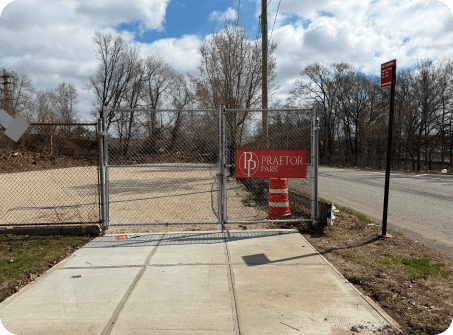 The entrance gate at Lot B with a traffic barrel beside it